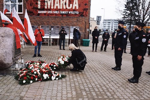 Złożenie kwiatów pod pominikem -dyrektor szkoły